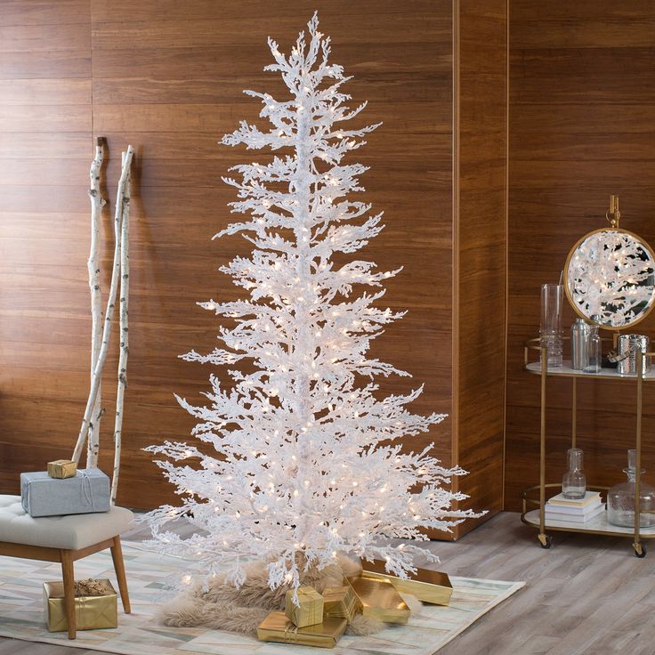 a white christmas tree sitting on top of a wooden table