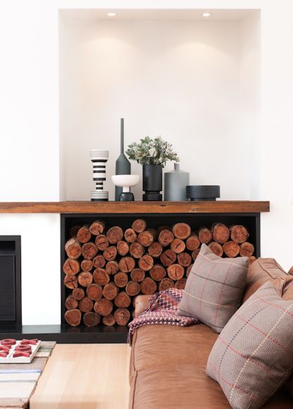 a living room filled with furniture and a fire place next to a wall mounted fireplace