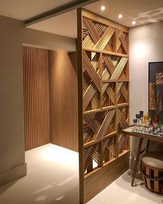 a room with a table and stools next to a wooden book shelf filled with books