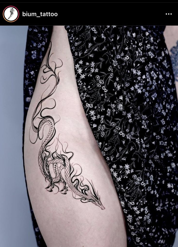 a woman's thigh with a dragon tattoo on it