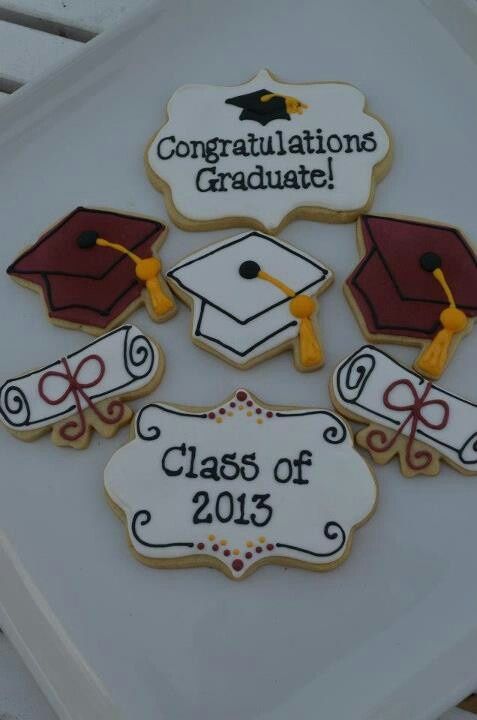 decorated cookies with graduation caps and tassels are on top of a white tray