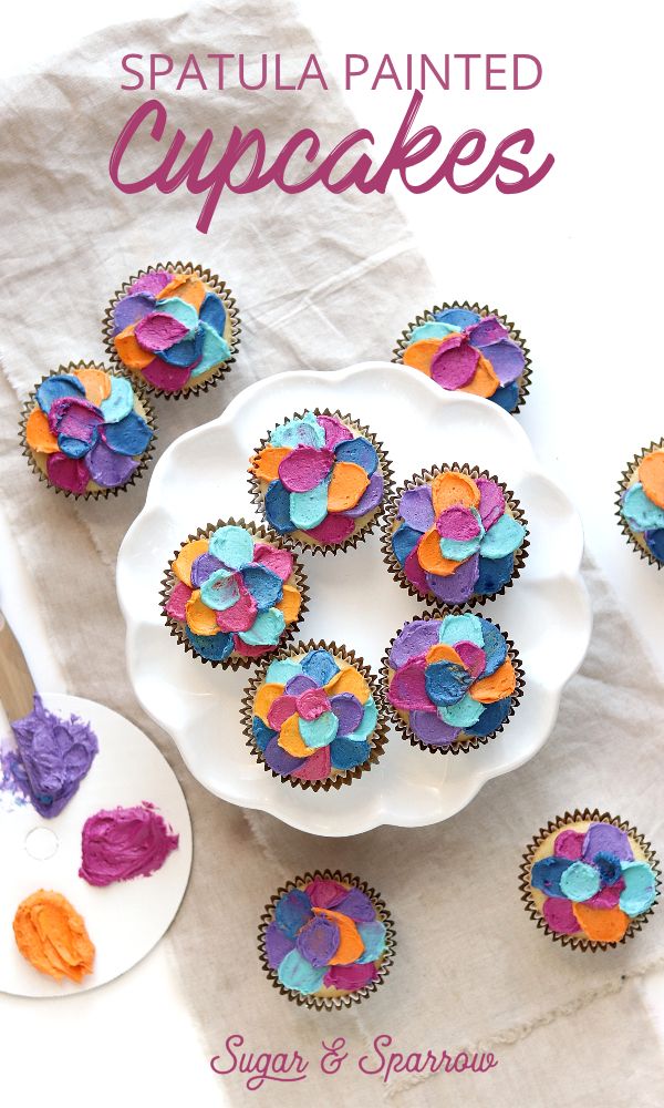 there are cupcakes with colorful icing on the plate