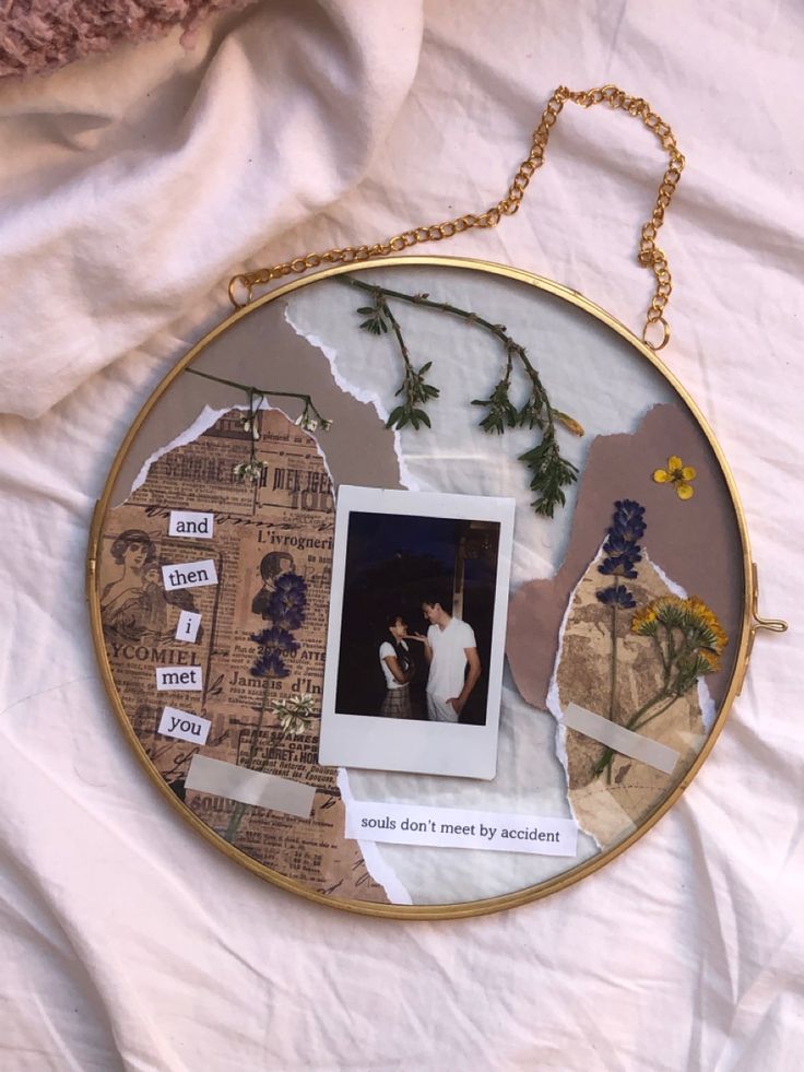 a collage of photos and torn paper on a white sheet with a gold chain hanging from it