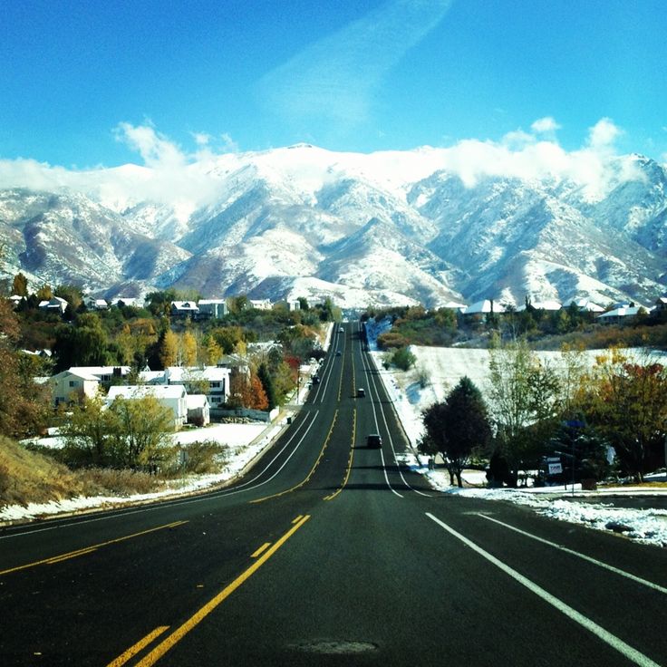 an empty road with mountains in the background