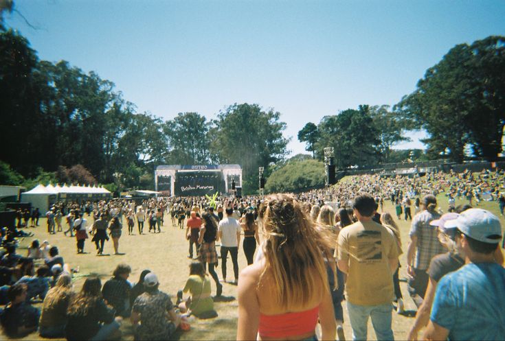 a large group of people standing in front of a stage at a music festival or concert