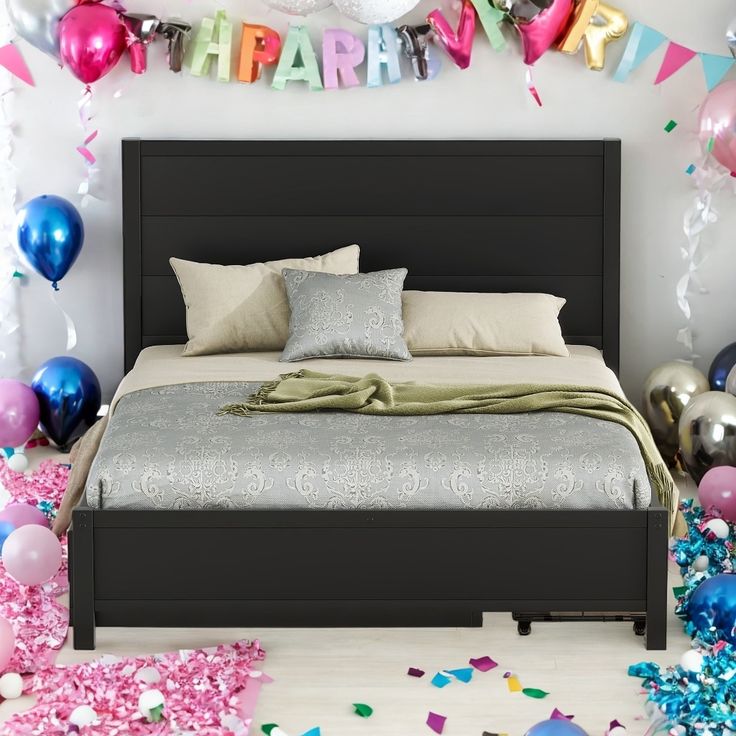 a bedroom decorated with balloons, streamers and confetti for a birthday party