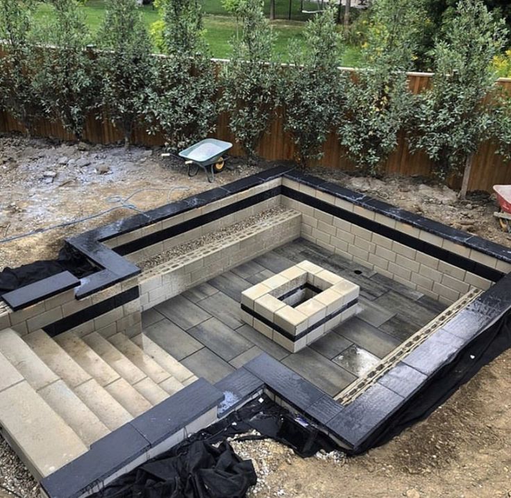 an outdoor fire pit in the middle of a yard that has been built into it