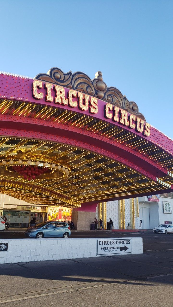 a carnival with cars parked in front of it and the word circus circus on top