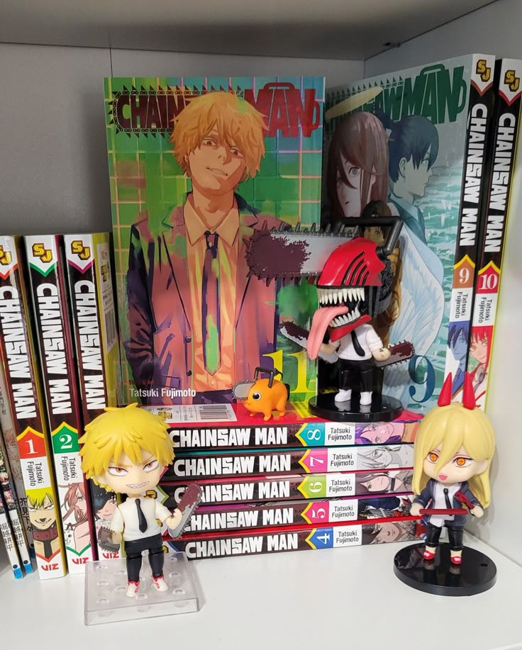 some anime figurines are sitting on a shelf in front of books and dvds