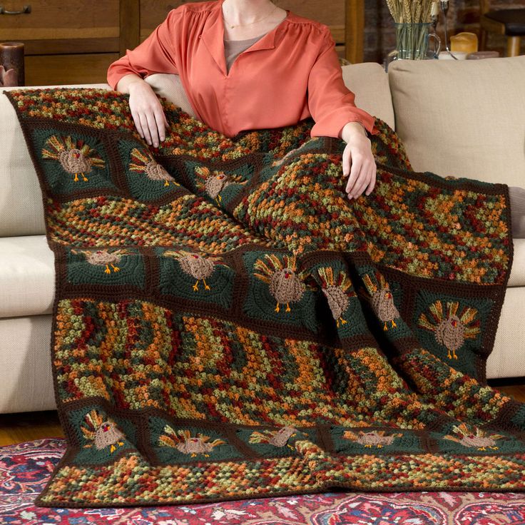 a woman is sitting on a couch holding a blanket