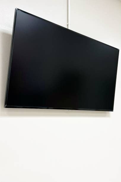 a flat screen tv mounted to the side of a wall next to a white wall