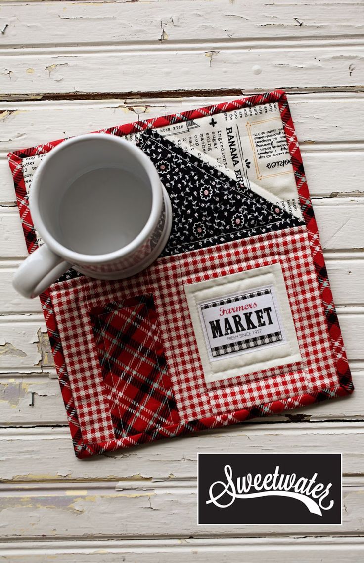 a cup and saucer sitting on top of a red checkered place mat with the words market