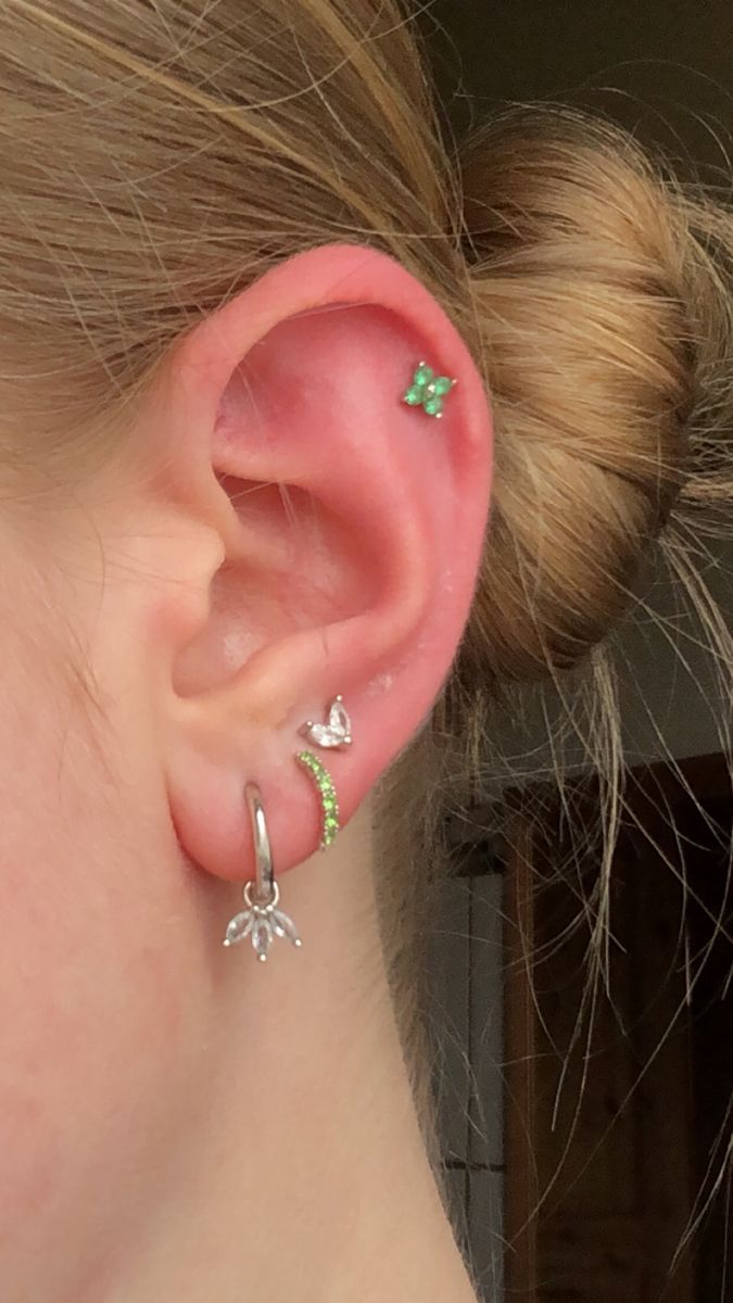 a close up of a person's ear with two piercings on it and one behind the ear