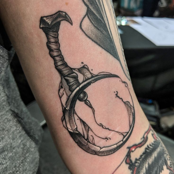 a man's arm with a tattoo on it and an arrow in the middle