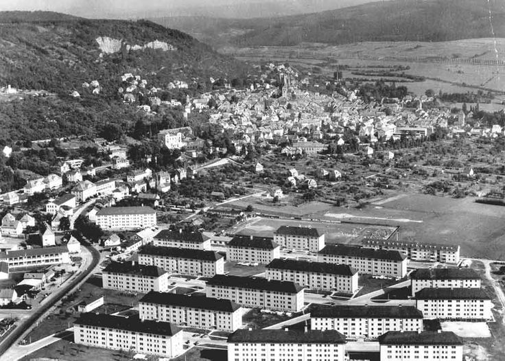 an aerial view of a city with many buildings in the foreground and mountains in the background