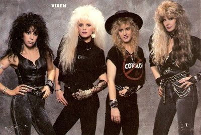 four women in black outfits posing for a magazine cover with long hair and piercings