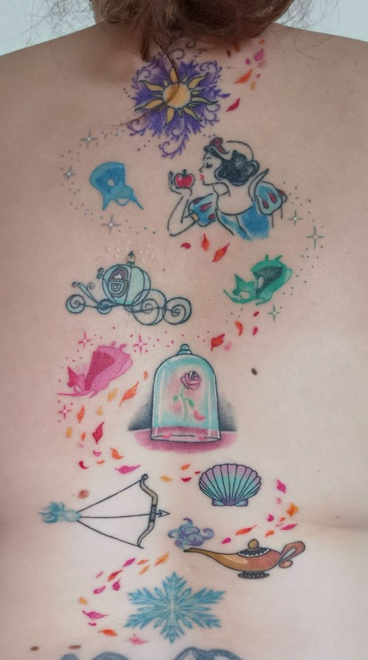 the back of a woman's stomach with tattoos on it and various things around her