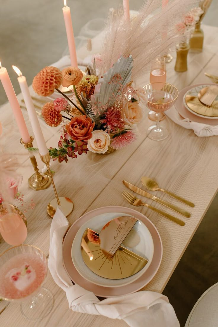 the table is set with candles, plates and napkins