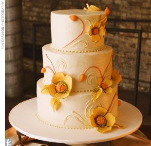 a three tiered cake with yellow flowers on it