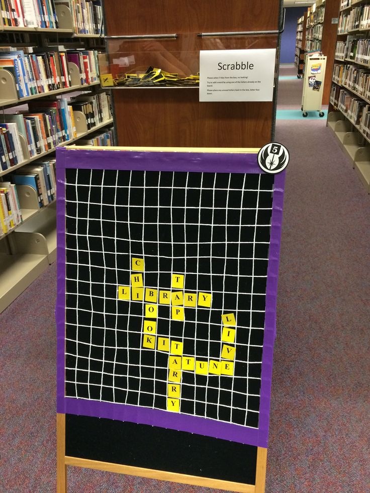 a purple and black sign with yellow letters on it in a bookstore aisle next to bookshelves