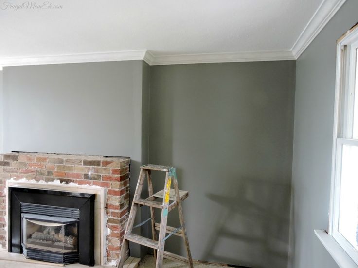 an empty room with a brick fireplace and ladder