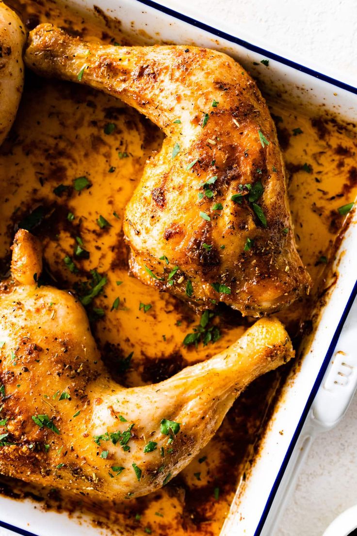 a chicken in a casserole dish with garnishes on the side