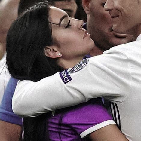 a man and woman embracing each other in front of a group of people at a sporting event