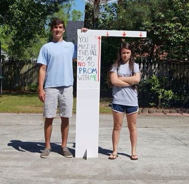 two people standing in front of a sign