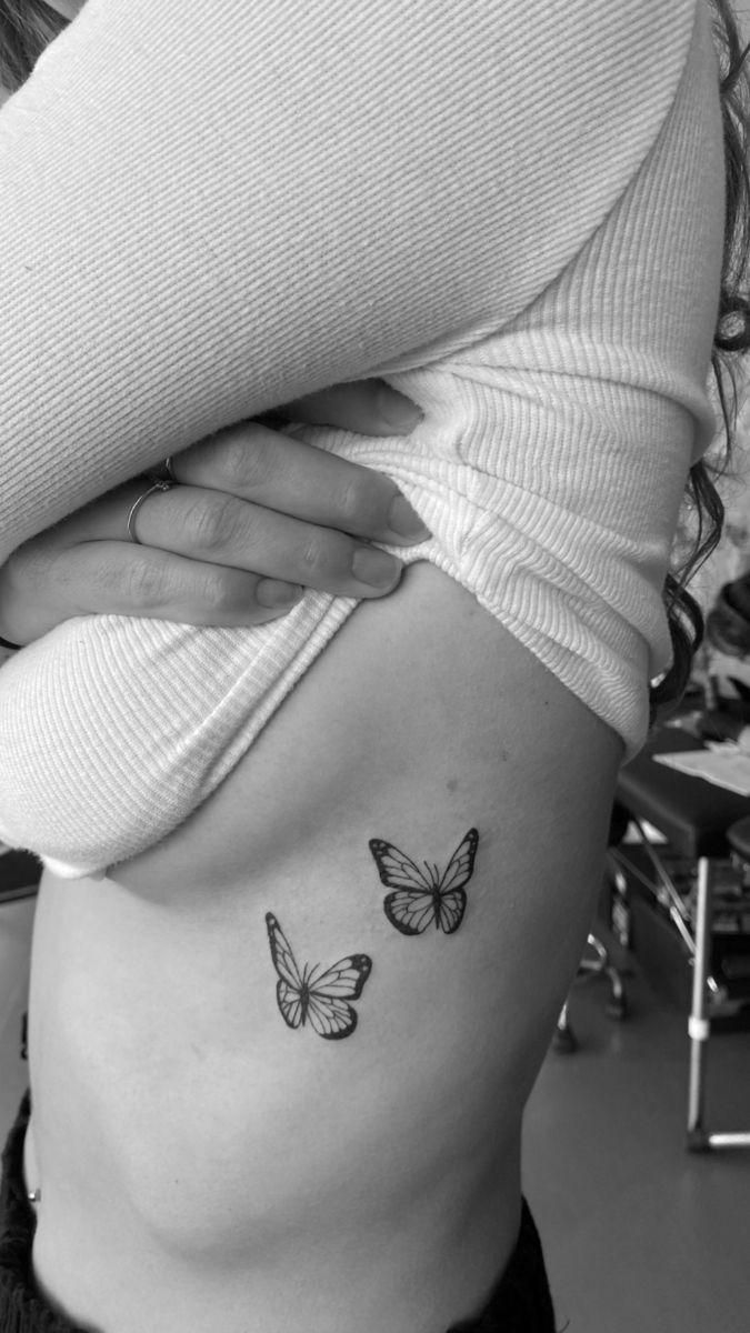 a woman's stomach with two butterflies on her side, and the bottom part of her belly