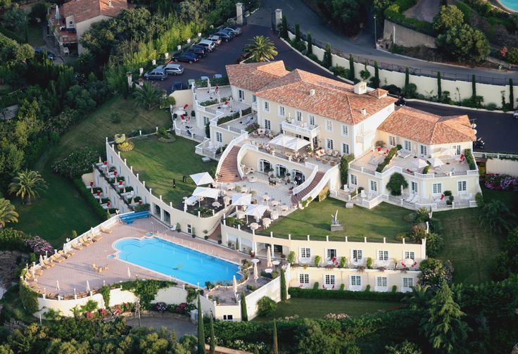 an aerial view of a mansion with a swimming pool