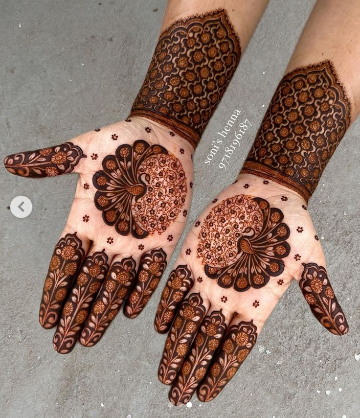 two hands with henna designs on them, one is brown and the other is white