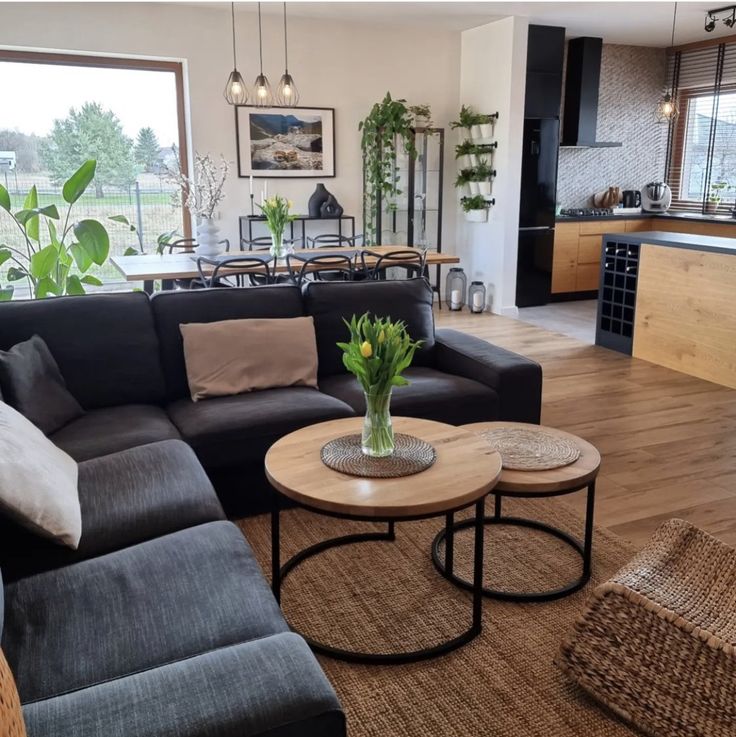 a living room filled with furniture next to a kitchen