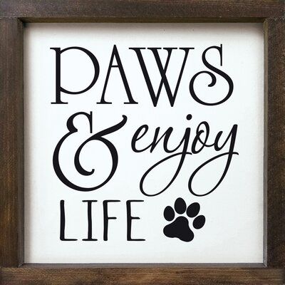 a framed sign that says paws and enjoy life with a dog's paw on it