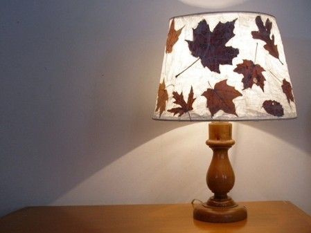 a lamp that is sitting on top of a wooden table next to a white wall