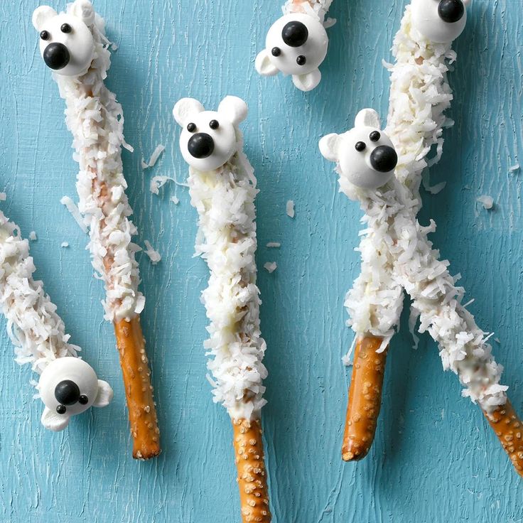 four polar bear pretzels are made out of rice and carrot sticks with black noses