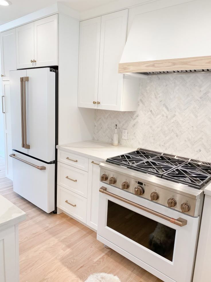 a white kitchen with an oven and refrigerator