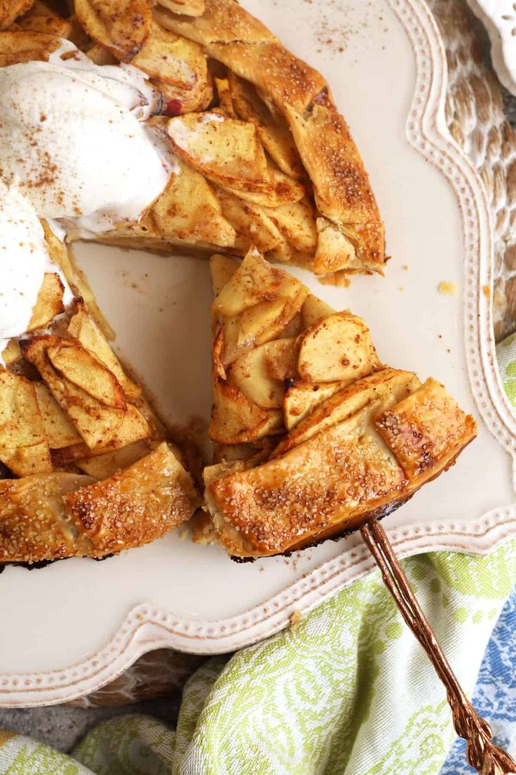 an apple pie on a plate with some whipped cream