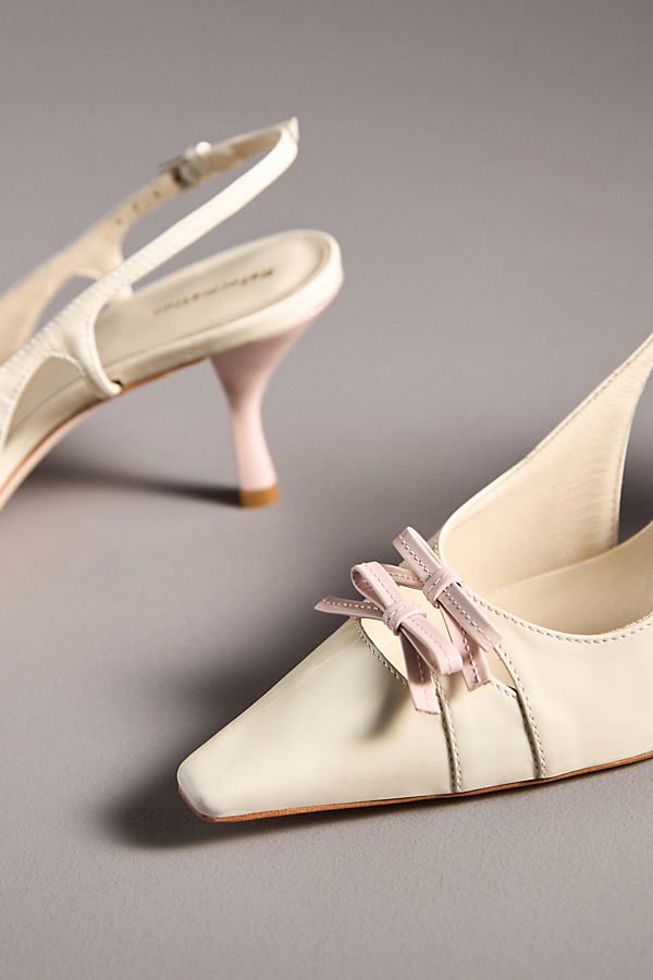 The Reformation Noreen Slingback Heels exude vintage charm with their elegant slingback design, pointed toe, and delicate bow details. | Noreen Slingback Heels by Reformation in White, Women's, Size: 7, Leather/Rubber at Anthropologie Ivory Slingback Heels, Wedding Slingback Kitten Heels With Heel Strap, White Feminine Slingback Heels, Chic Slingback Kitten Heels With Bow, Chic Slingback Wedding Shoes With 4-inch Heel, Womens Work Shoes, Slingback Kitten Heels, Sling Back Heels, Commitment Issues