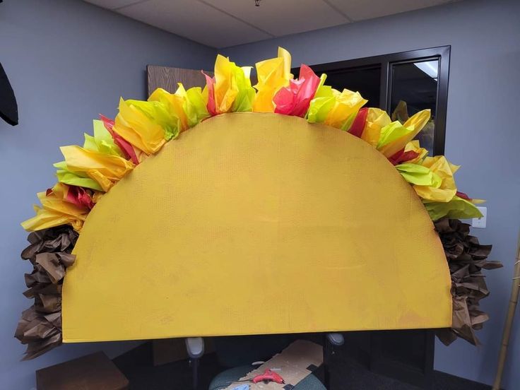 an office cubicle decorated with paper flowers and other things on the desk, as well as a sun hat