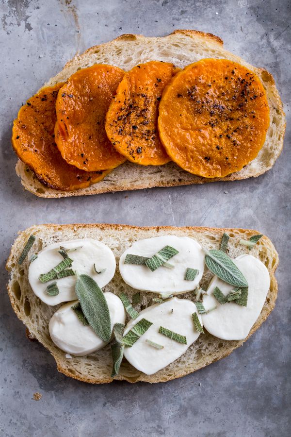 two slices of bread with cheese and herbs on them