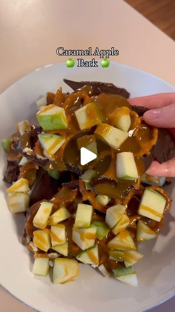 someone is holding onto some food on a plate with caramel and apple toppings