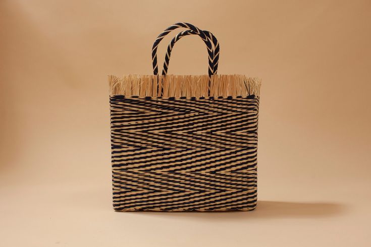 Handwoven tote with natural frilled border in ocean blue and natural straw. The inside is lined with natural fabric to protect your belongings.     DETAILS Material: Palm  Measurements: H 34cm, W 36cm,  D 13cm, Handles L 18 cm  Origin: Piura -    CARE Wipe with clean wet cloth Chic Blue Handwoven Straw Bag, Blue Woven Basket Straw Bag, Blue Straw Tote Bag, Blue Woven Jute Bag, Blue Straw Shopping Bag, Chic Blue Woven Straw Bag, Blue Straw Bag With Braided Handles, Rectangular Blue Straw Bag, Blue Jute Tote Bag