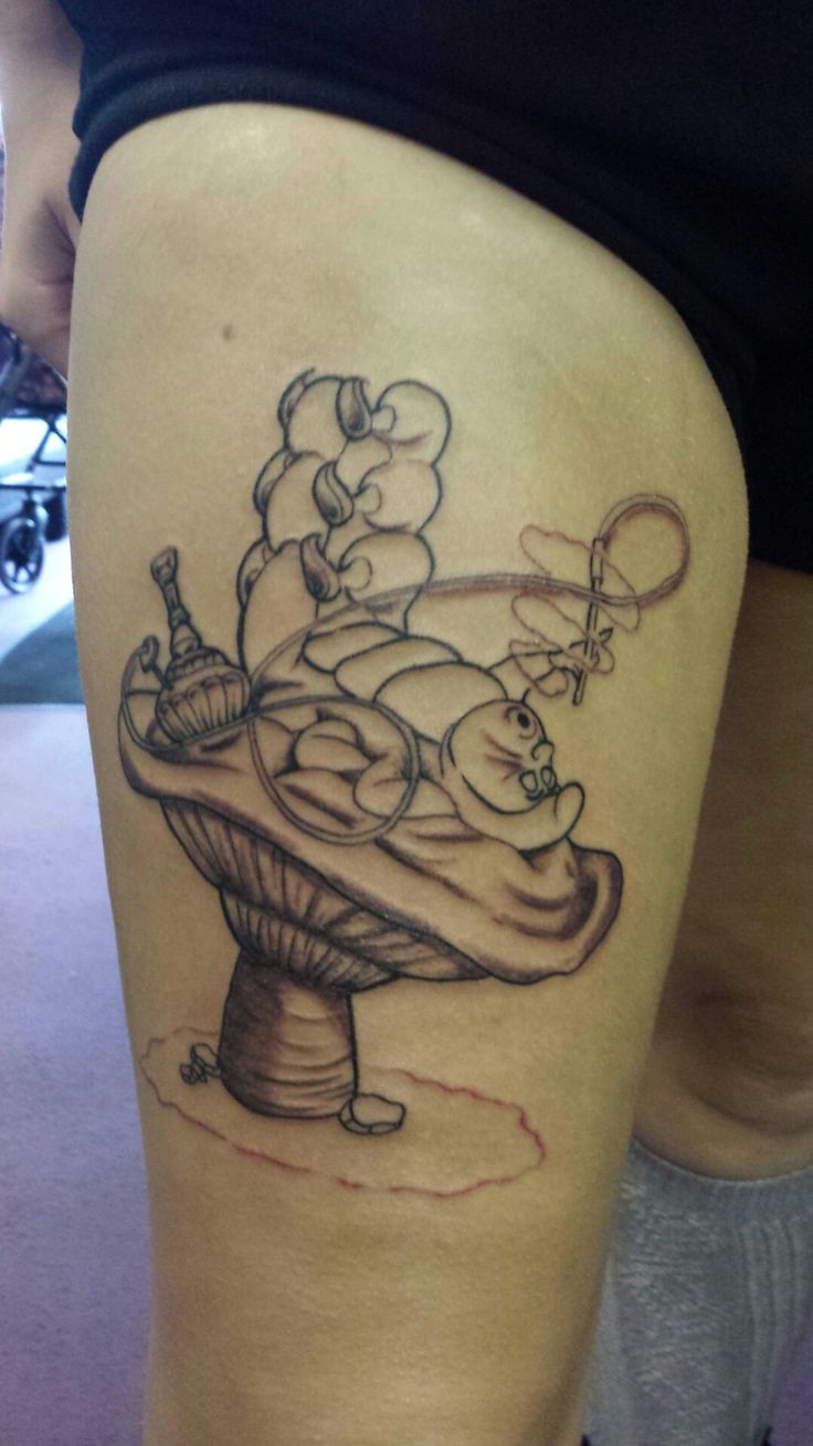 a woman's thigh with a tattoo on it that has an image of a cake