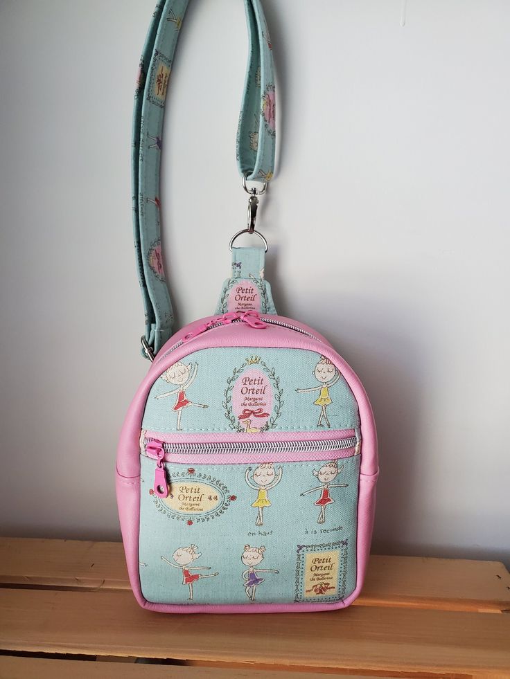 "How completely adorable is this Mav Sling bag Absolutely the best little bag to carry your wallet phone and keys around the parks or shopping! Just the right size for any age. Beautiful Cotton Canvas on the front with beautiful Ballerinas dancing. The cute pink zipper pull in the front just adds to the cuteness!! Inside is a water proof canvas that can be wiped out. The two zipper pulls that close the top! The strap is the same cute Ballerina canvas material with a clasp attachment at the top and in the back. The back d ring slides so that now matter what side you wear your cute sling on it will adjust and be the perfect fit. This cute strap can adjust out to 42\". Size of the Mav Sling: 7 1/2 inches tall x 6 inches wide x 3 inches deep Last picture is the bag size on a 7 year old.  Patte Pink Phone Bag With Removable Pouch For Travel, Cute School Pouch Phone Bag, Cute Pouch Phone Bag, Cute Everyday Pouch Phone Bag, Cute Travel Phone Shoulder Bag, Cute School Phone Pouch Bag, Cute Pink Shoulder Bag With Zipper Pouch, Cute Travel Phone Bag Pouch, Cute Bags With Cell Phone Pocket For Everyday