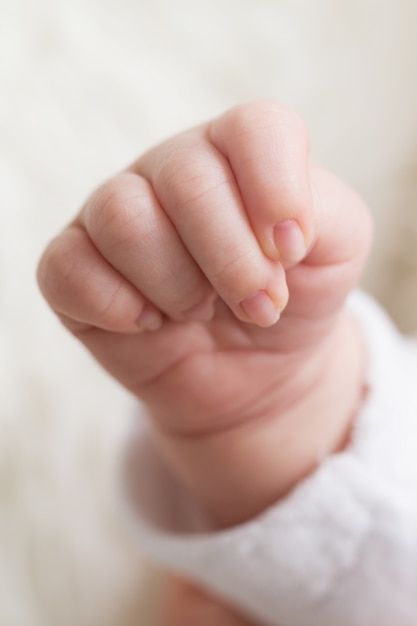 a close up of a baby's hand pointing at the camera with its thumb