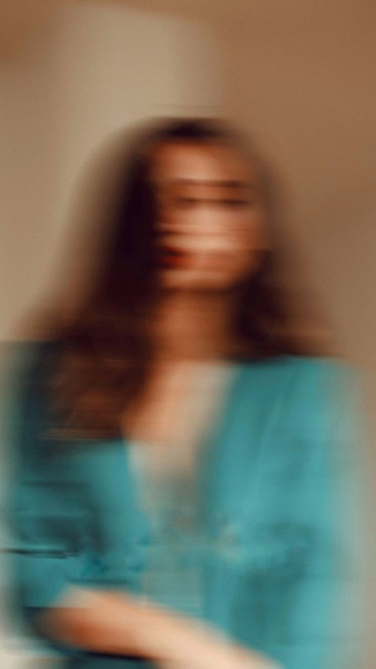 a blurry photo of a woman holding a cell phone