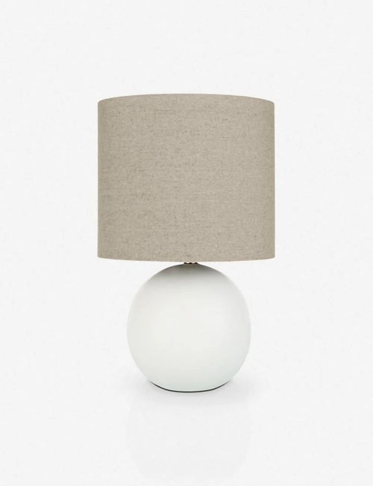 a white table lamp with a beige shade on the base and a light brown linen shade on the top