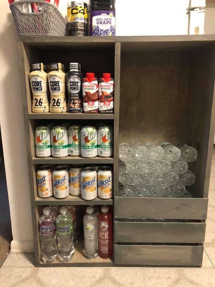 an open cabinet filled with lots of different types of drinks and condiments on top of it