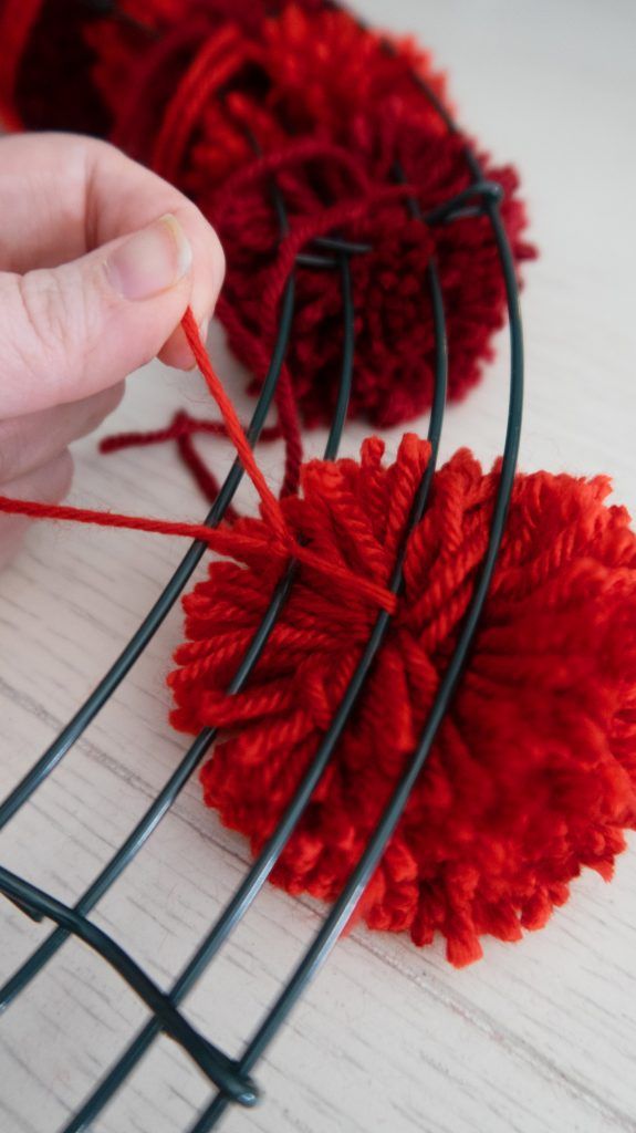 someone is knitting red yarn on the table