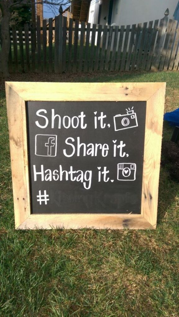 a sign in the grass that says shoot it share it hashtag it with a camera